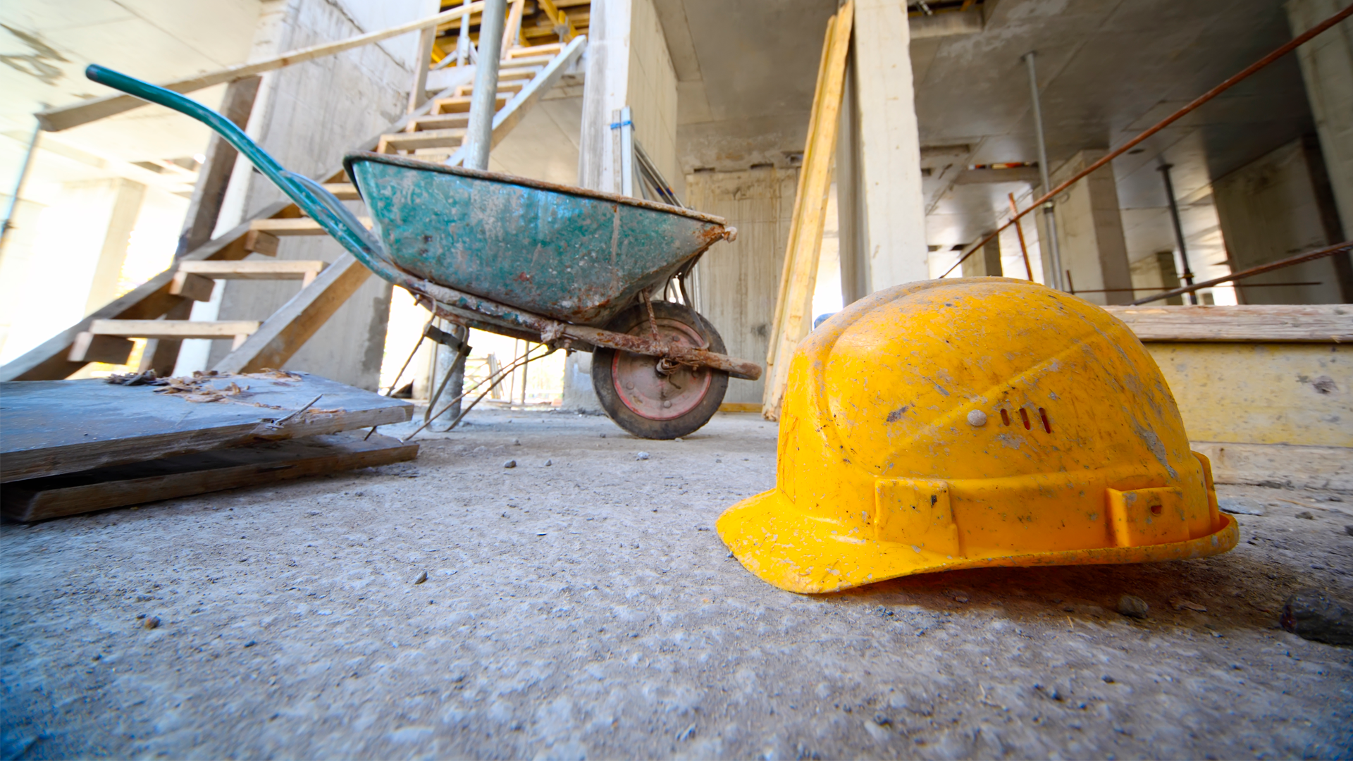 Casco de seguridad y carretillo en piso de eficicio en construcción. IPCONS Marzo 2023.