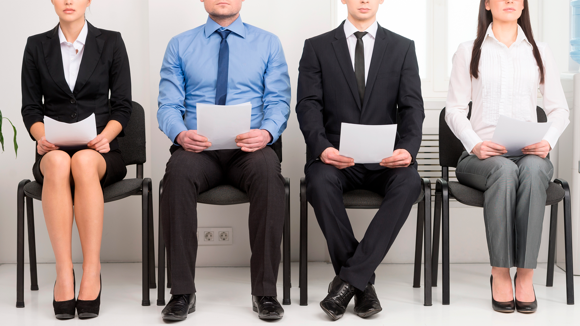 Cuatro personas sentadas en fila con curriculum en la mano, esperando por entrevista de trabajo. ECE, primer trimestre 2023.