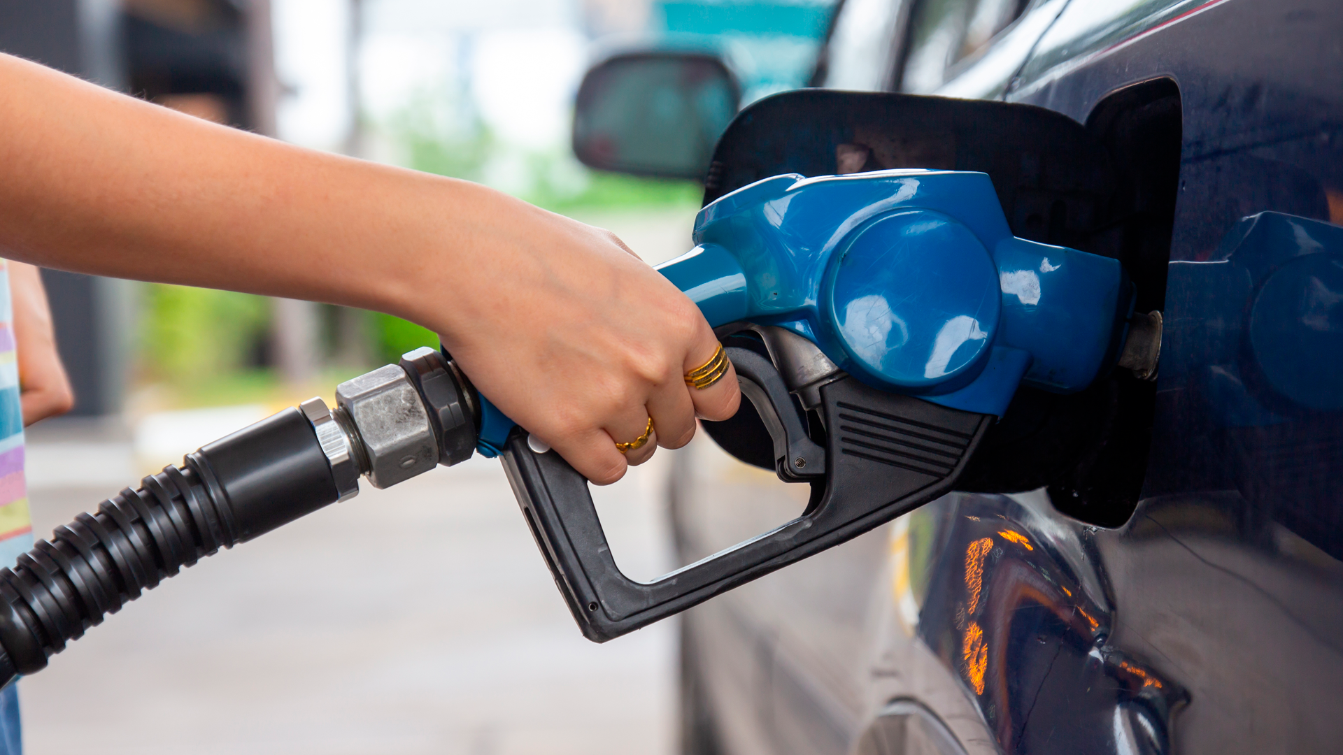 Mano de mujer poniendo combustible en automóvil. IPC Abril 2023.