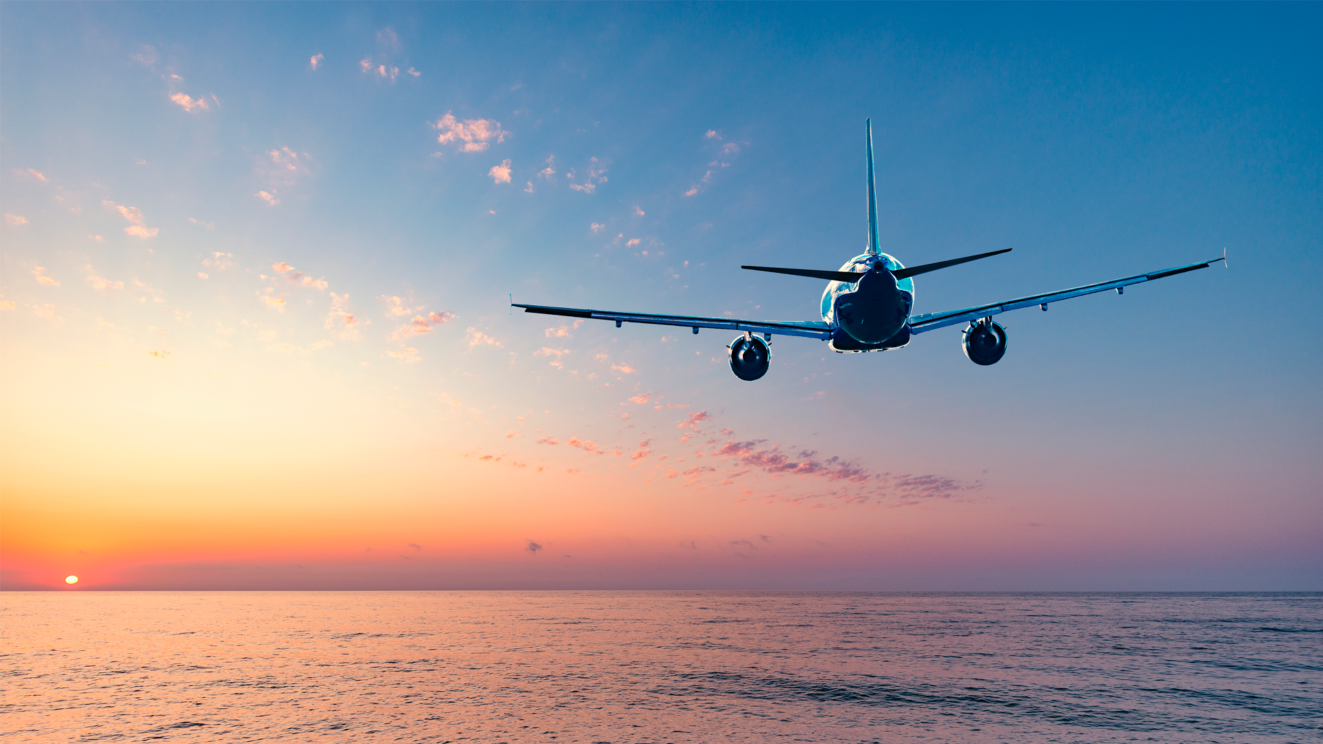 Avión viaja sobre el mar, hacia el horizonte, durante el atardecer. IPC. Julio 2023.