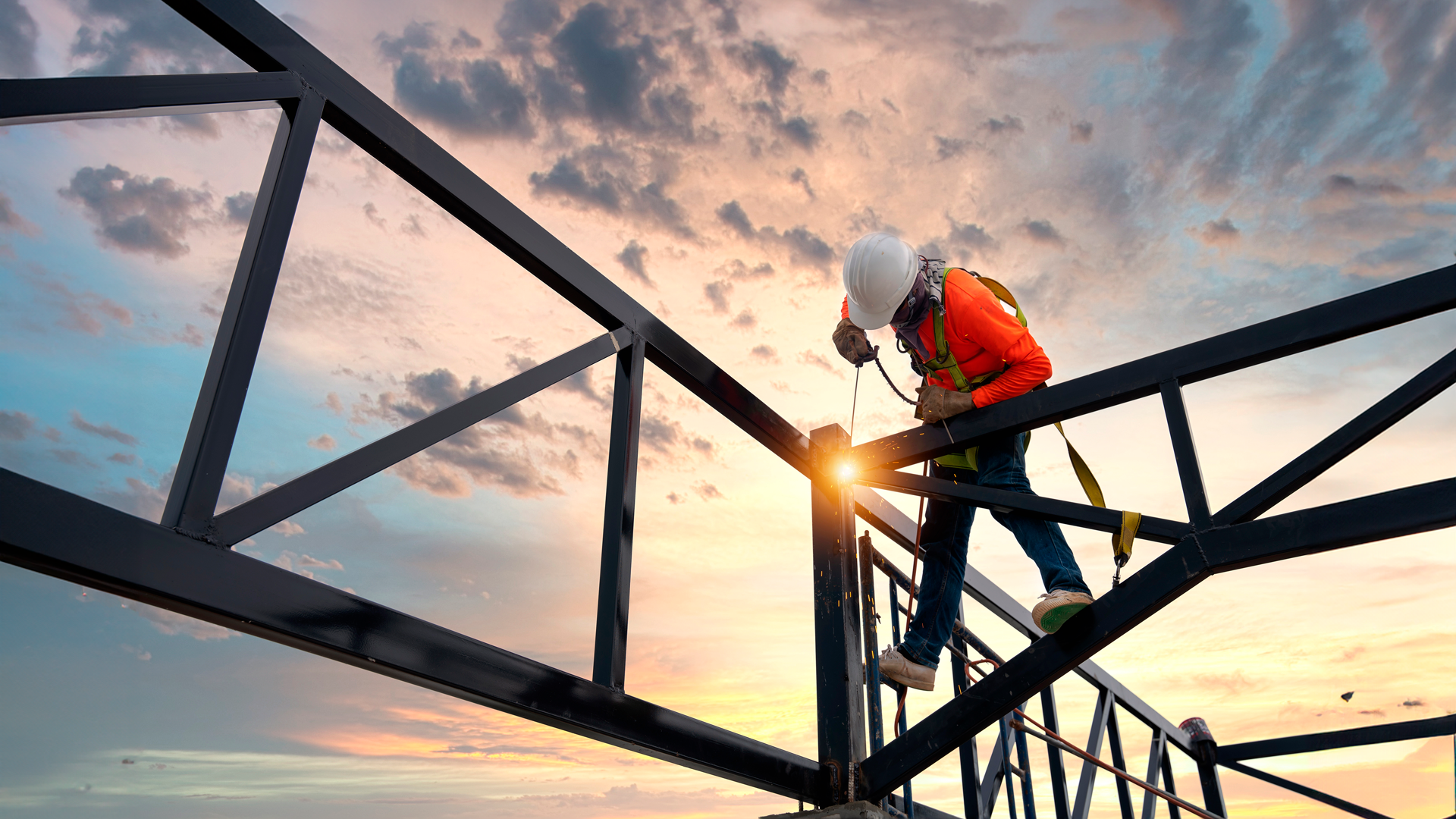 Trabajador soldando estructura metálica en en techo de edificio en construcción. IPConstrucción. ENE 2024.