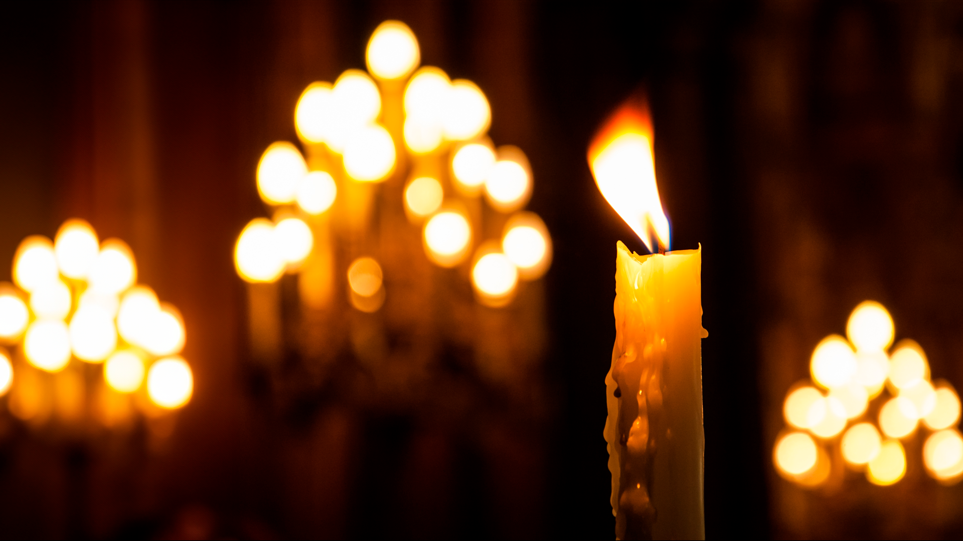 Vela de cera en ambiente iluminado con velas. Semana Santa 2024.