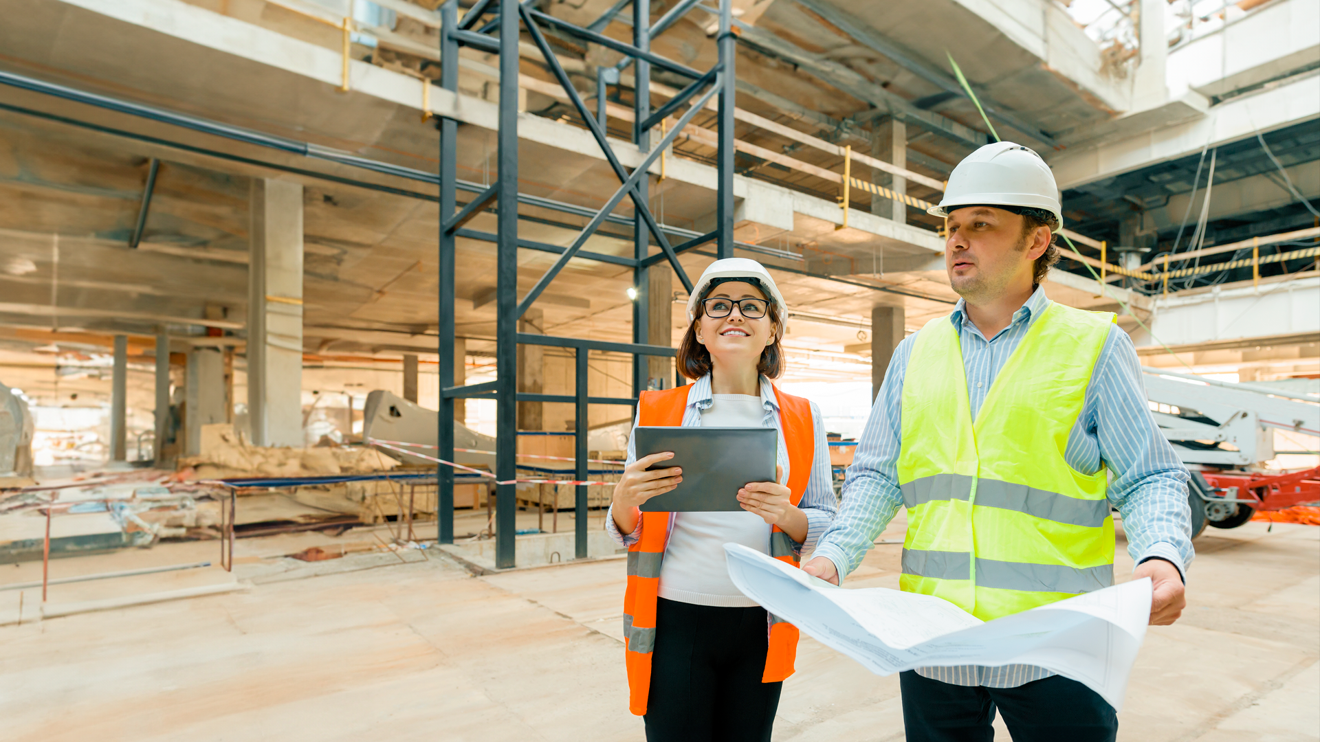 Trabajador y trbajadora de la construcción observan obra y planos. ENADEL 2023. Resultados.