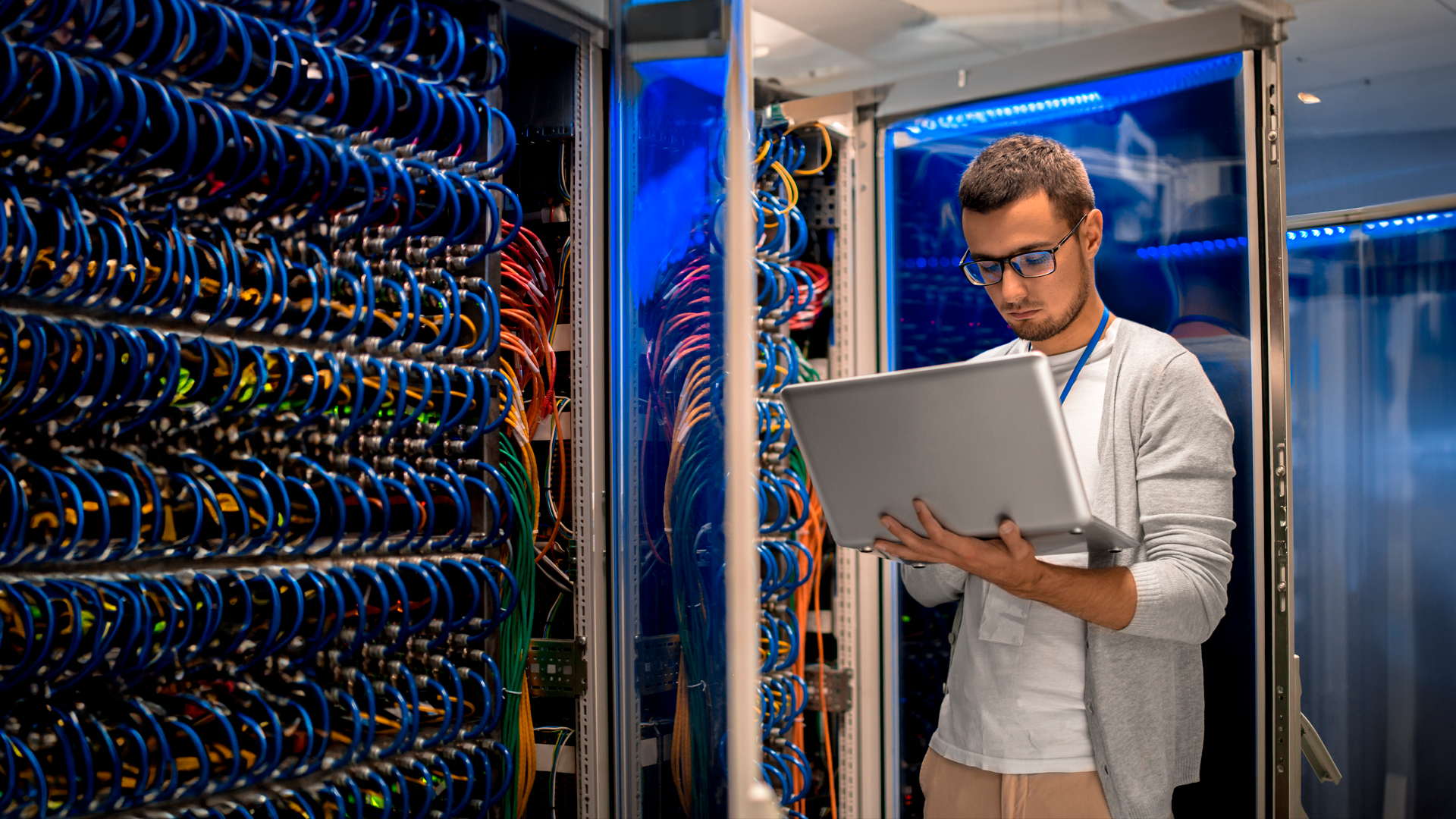 Trabajador de tecnologías de información revisa computadora portatil en cuarto de servidores. ECE. III TRIM 2024.