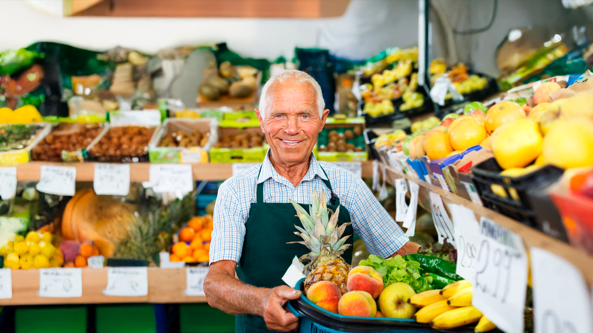 Hombre adulto trabaja en tienda de frutas y verduras acomodando producto. ECE. TRIM EFM 2025.