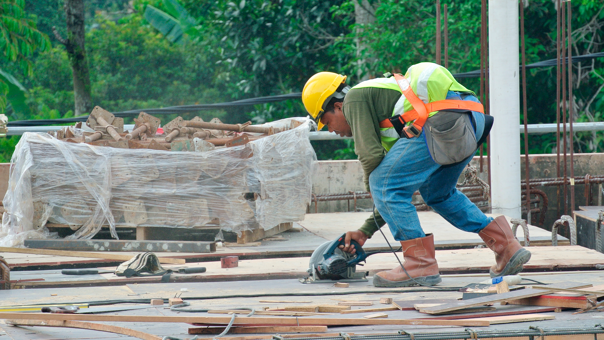 Trabajador de la construcción utiliza sierra eléctrica en construcción de edificio.
