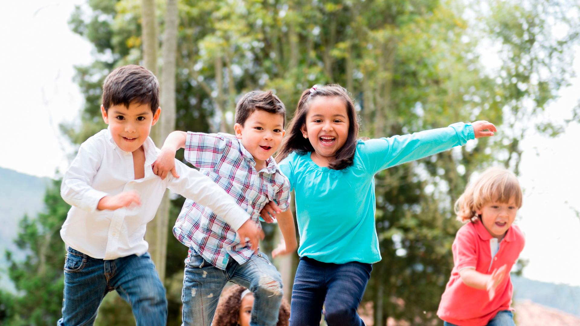 Niños en niñas corriendo en parque al aire libre en día soleado. Día de la niñez 2023.